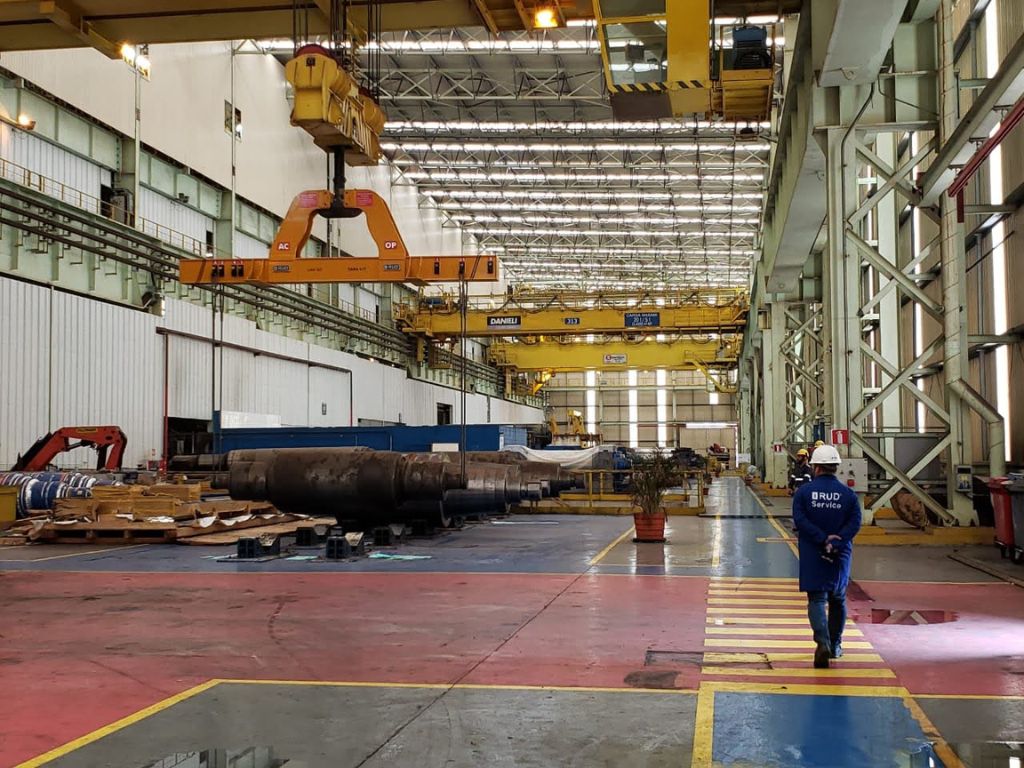 Operação industrial com dispositivo de içamento projetado utilizado na movimentação segura de carga pesada em ambiente fabril